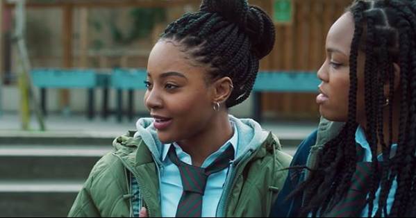 Filmszene aus Blue Story. Zwei Freundinnen auf dem Schulhof in London.