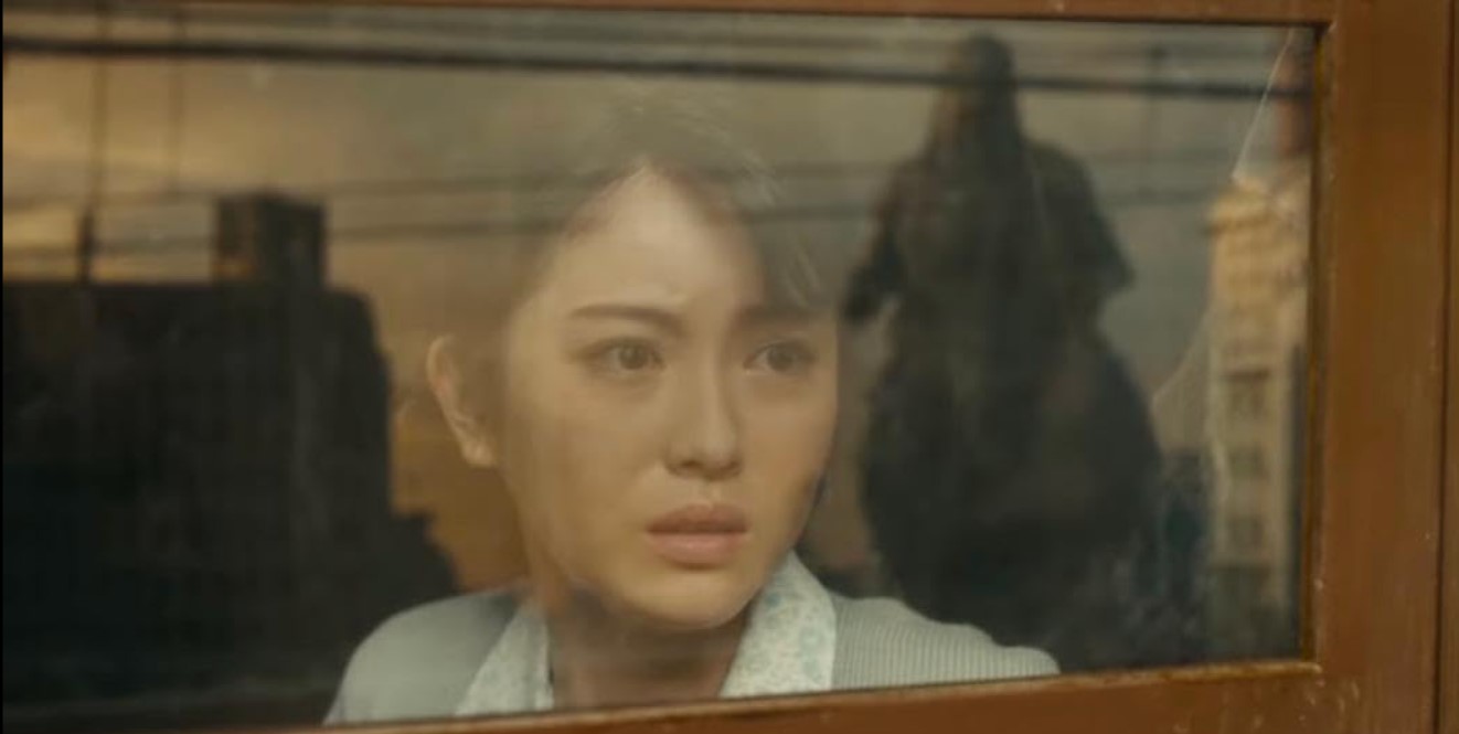 Entsetztes Gesicht einer jungen Frau, als sie die Kreatur Godzilla sieht.